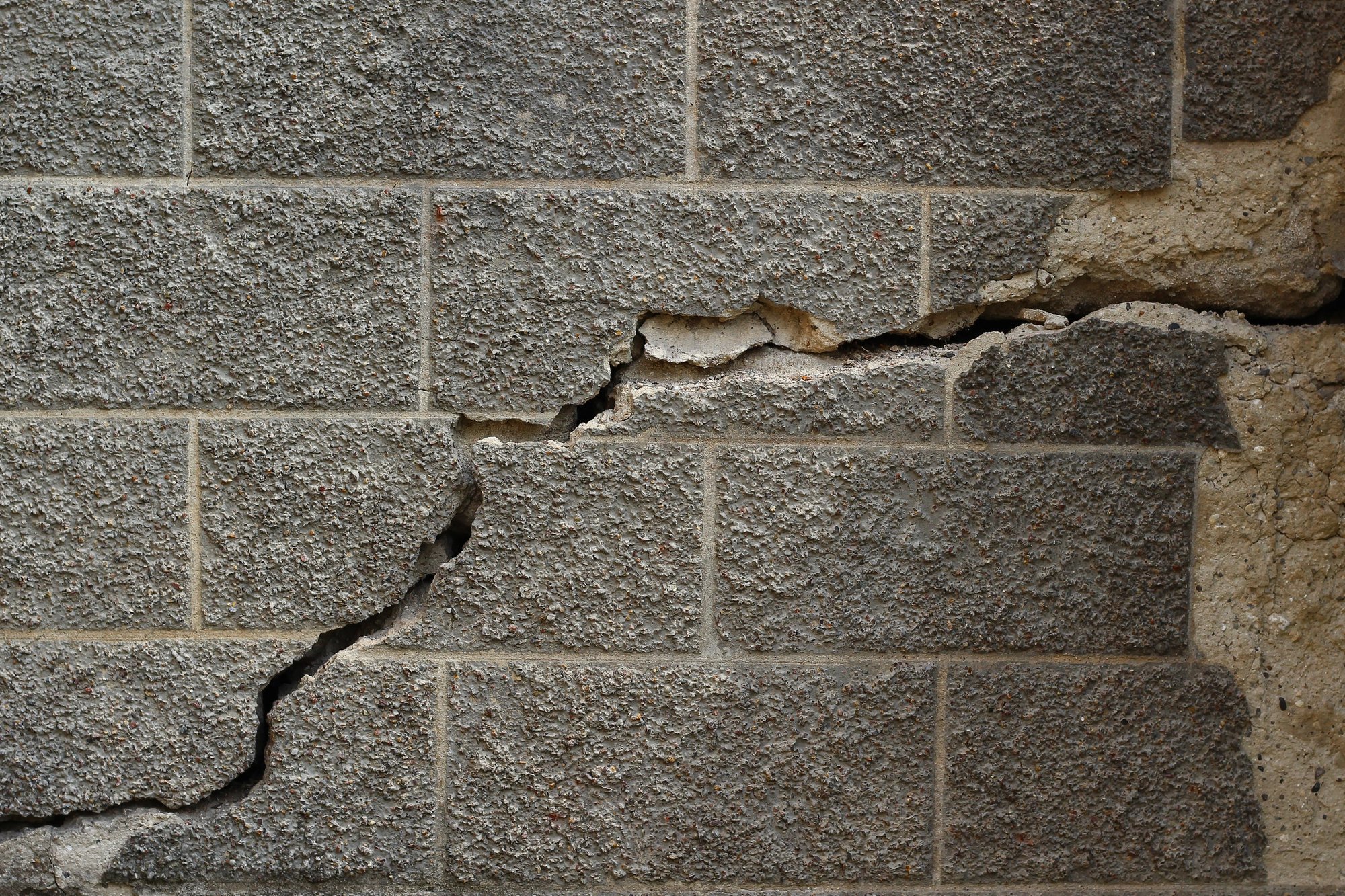 Stair-step crack running through a concrete block foundation wall